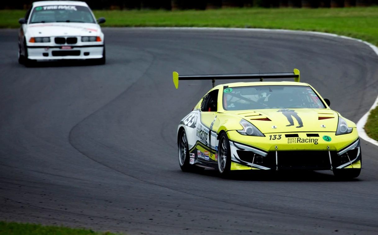 The BGR Racing Nissan 370Z in its yellow and white wrap, cornering on track