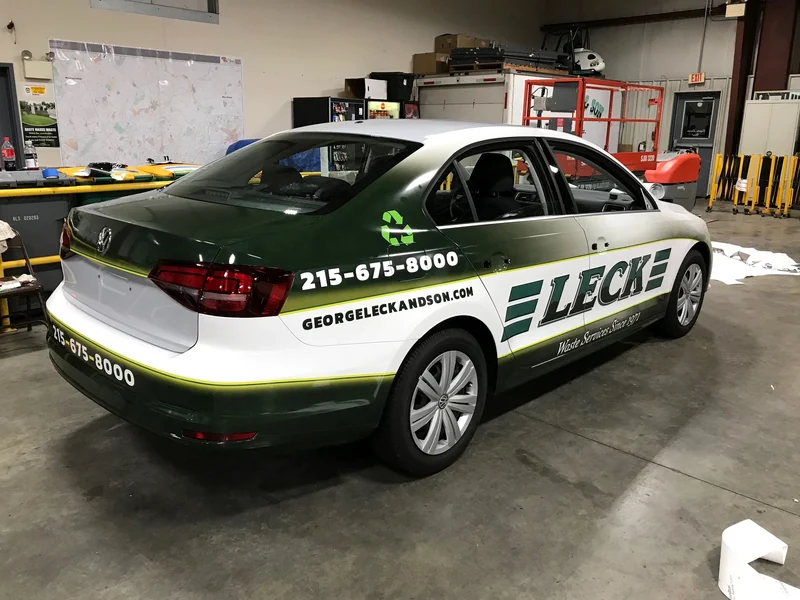 A LECK Sales sedan in green and white livery, finished in the shop